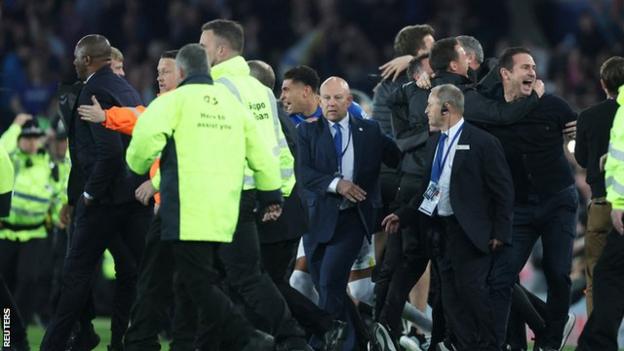 Crystal Palace boss Patrick Vieira (left) is escorted off the pitch at Goodison Park following a pitch invasion by fans