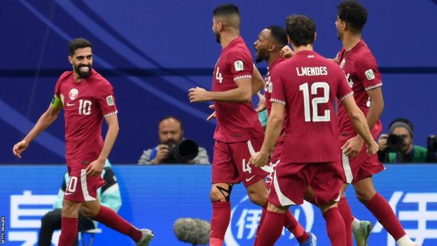 Qatari players celebrate after scoring a goal in the Asian Cup quarterfinals against Uzbekistan