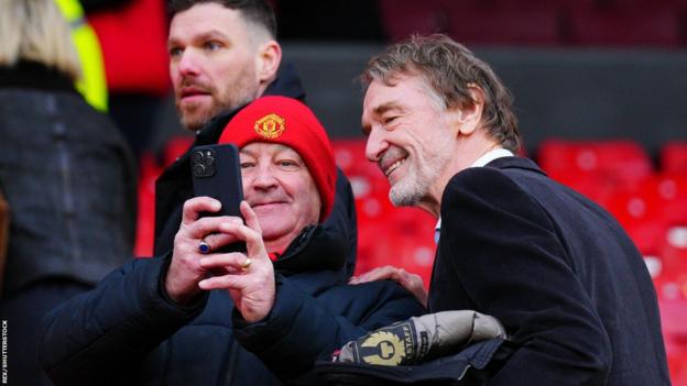 Sir Jim Ratcliffe poses for a selfie with a Manchester United fan at Old Trafford