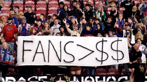 Newcastle Jets fans hold a banner protesting against the APL
