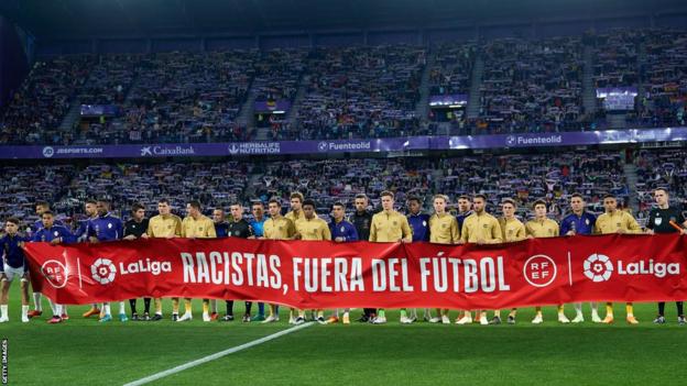 Real Valladolid and Barcelona players hold up an anti-racism banner