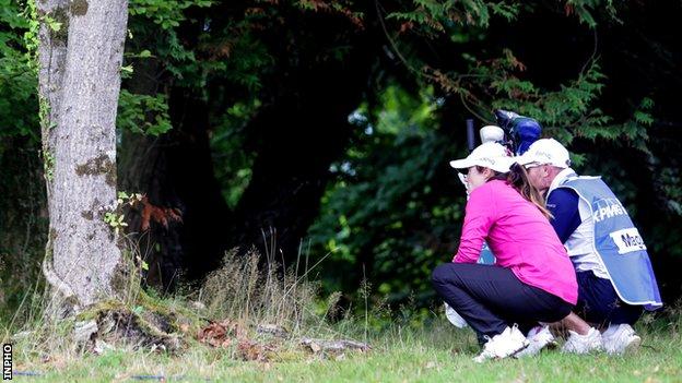 Leona Maguire tries to plot an escape from the trees at the second hole on Friday