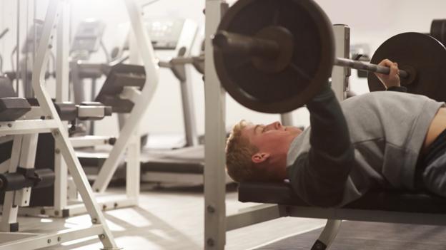 Stock image of man lifting weights in the gym