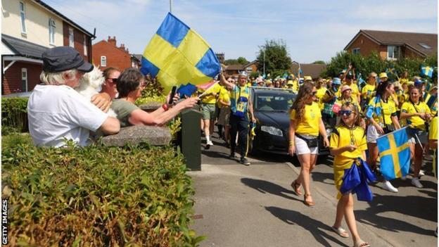 Locals in Leigh stand in the garden to cheer Sweden fans on their way to the game with Portugal