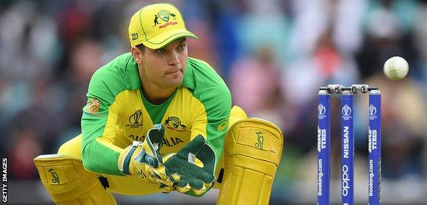 Australia wicketkeeper Alex Carey bends low to catch a ball against Sri Lanka