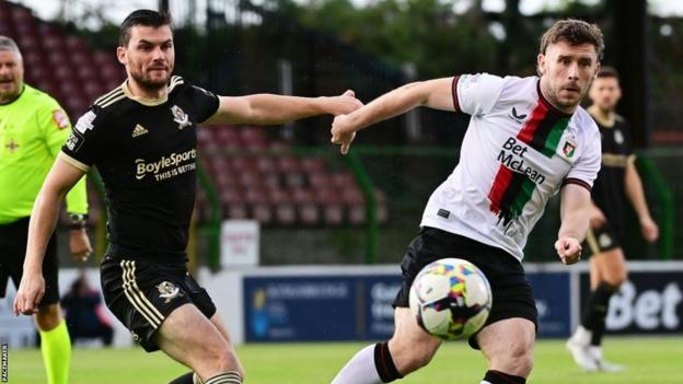 Philip Lowry and Shay McCartan in action during the first half