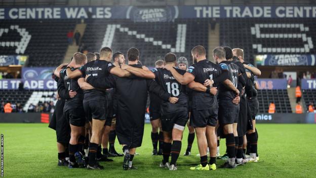 Ospreys players in a huddle.