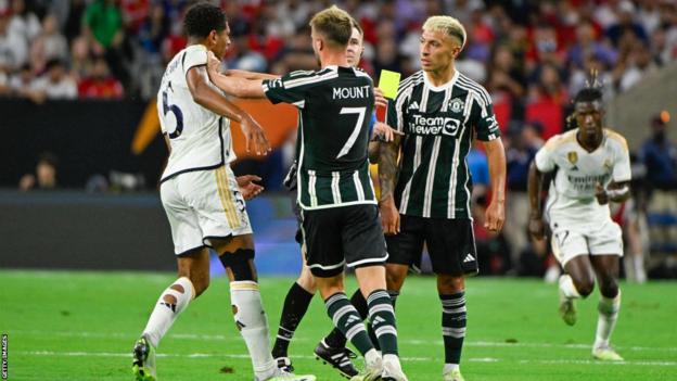 United's Martinez, right, clashes with Bellingham, left as Mount (centre) intervenes. Referee Lukasz Szpala booked Martinez.