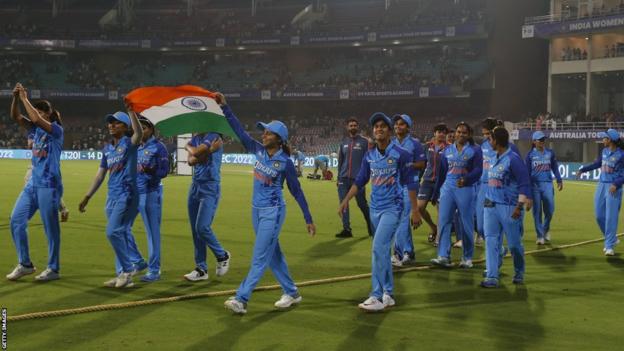 Equipo femenino indio dando una vuelta de la victoria con una bandera india