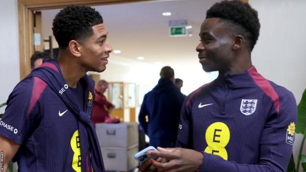 Bukayo Saka (right) talks to England team-mate Jude Bellingham