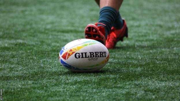 A player goes to kick a rugby ball