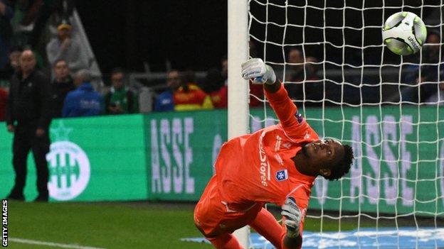 Auxerre goalkeeper Donovan Leon makes a save in the penalty shoot-out against Saint-Etienne