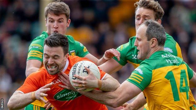 Aidan Forker attempts to break free from three Donegal opponents in the Ulster quarter-final