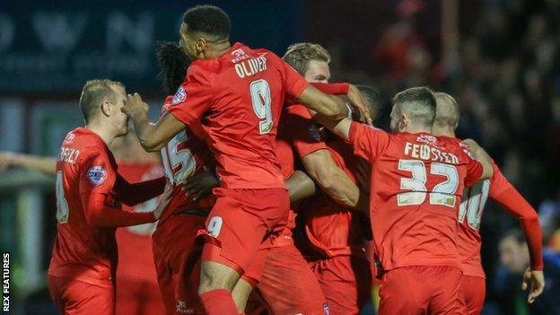 James Berrett is mobbed by his teammates after scoring what proved to be the winner