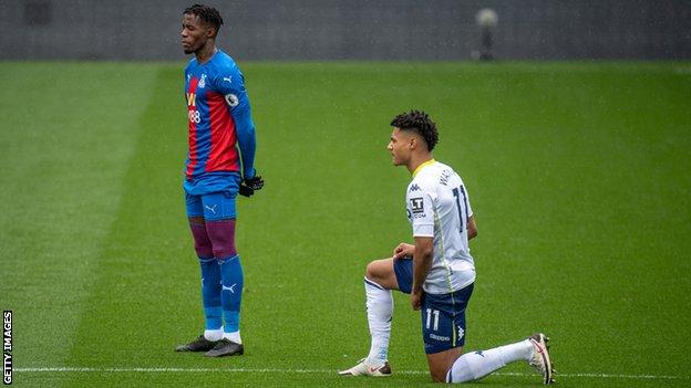 En février, l'attaquant de Crystal Palace Wilfried Zaha a déclaré qu'il cesserait de se mettre le genou avant les matchs