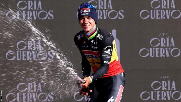 Remco Evenepoel celebrates with a bottle of champagne after winning stage three of the Vuelta a Espana