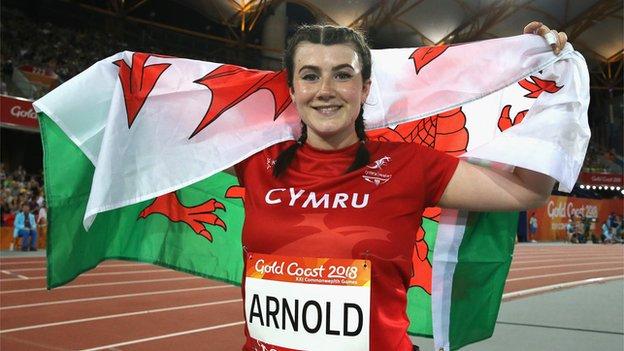 Hollie Arnold holds the Wales flag at the 2018 Commonwealth Games
