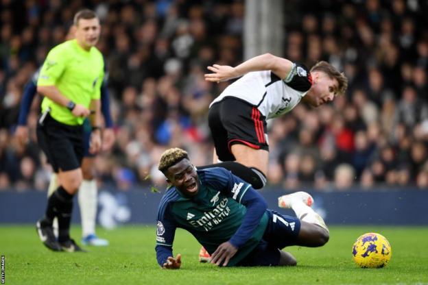 Arsenal winger Bukayo Saka is fouled by Fulham midfielder Tom Cairney