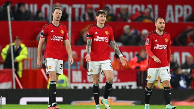 Manchester United players look dejected after defeat against Manchester City