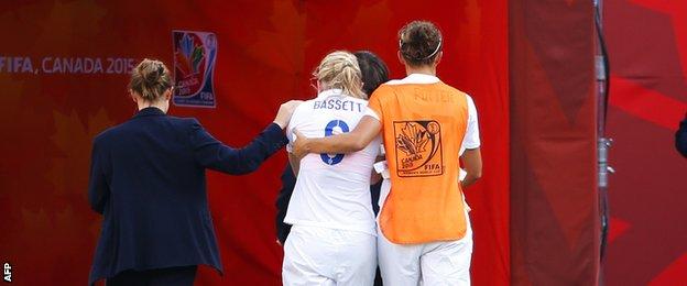 Laura Bassett of England is comforted by team-mates