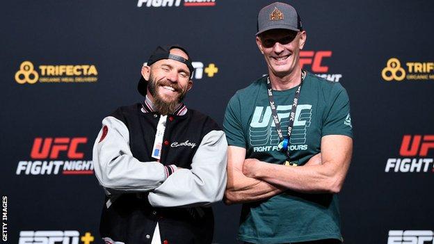 Jeff Novitzky hands Donald Cerrone a commemorative jacket for passing 50 drug tests in the UFC