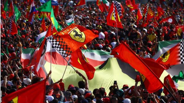 Ferrari flags are waved below the Monza podium to celebrate Carlos Sainz's third place