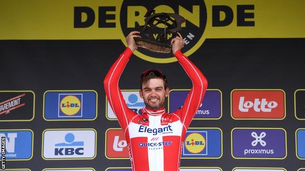 Denmark's Kasper Asgreen holds up the Tour of Flanders trophy on the podium