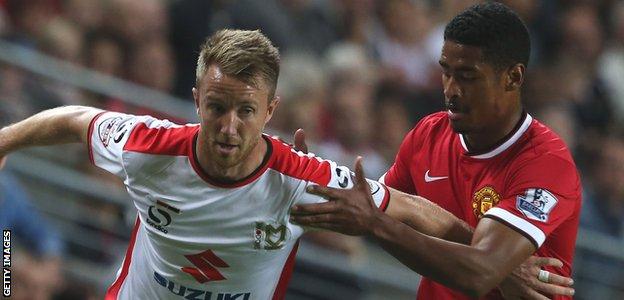 MK Dons forward Dean Bowditch and Manchester United full-back Saidy Janko battle for the ball