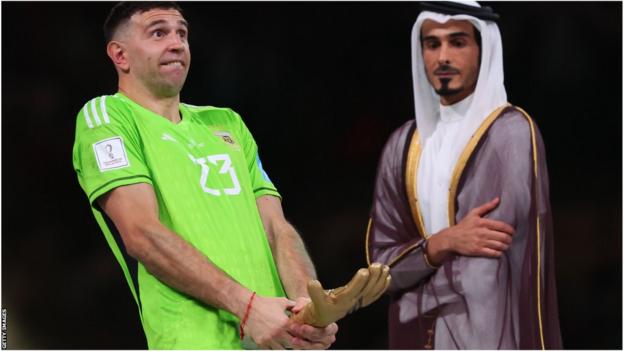Martinez célèbre avec le trophée Golden Glove de la Coupe du monde au Qatar, sous le regard d'un politicien qatari.