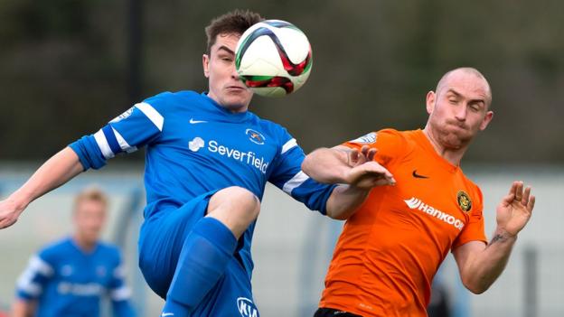 James McKenna of Ballinamallard in aerial action with Carrick Rangers midfielder Barry Johnston at Ferney Park