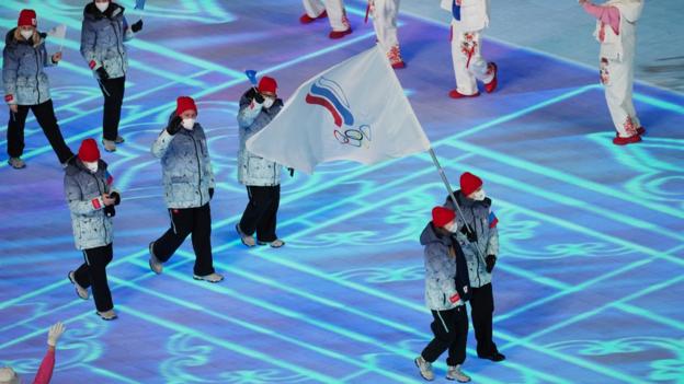 Défilé d'athlètes russes lors de la cérémonie d'ouverture des Jeux de Pékin portant un drapeau du Comité olympique