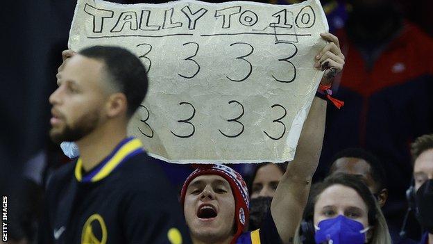 A fan waves a poster at Stephen Curry during the Golden State Warriors' defeat by the Philadelphia 76ers