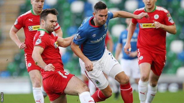 Cliftonville's Jamie Harney in action against Andrew Waterworth of Linfield