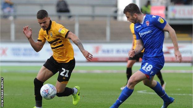 Tyler Forbes of Newport County takes on Morecambe's Rhys Oates