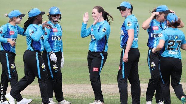 Amanda-Jade Wellington (centre) celebrates taking a wicket with her Adelaide team-mates Strikers