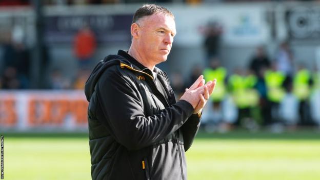 Graham Coughlan applauds fans at Newport's game with Salford