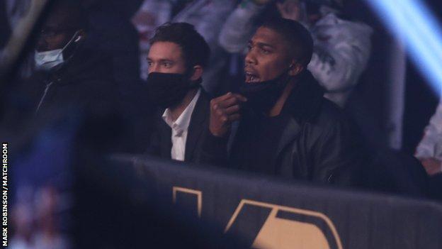 Le champion du monde des poids lourds unifié Anthony Joshua est assis au bord du ring alors qu'Oleksandr Usyk bat Derek Chisora ​​en novembre 2020