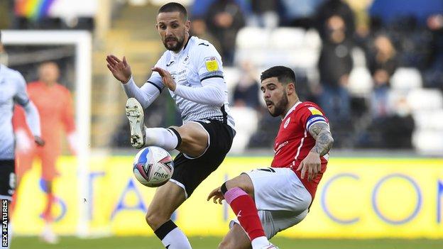 Swansea's Conor Hourihane challenges Barnsley's Alex Mowatt