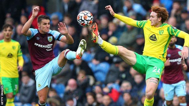 Matthew Lowton of Burnley competes for the ball with Josh Sargent of Norwich City