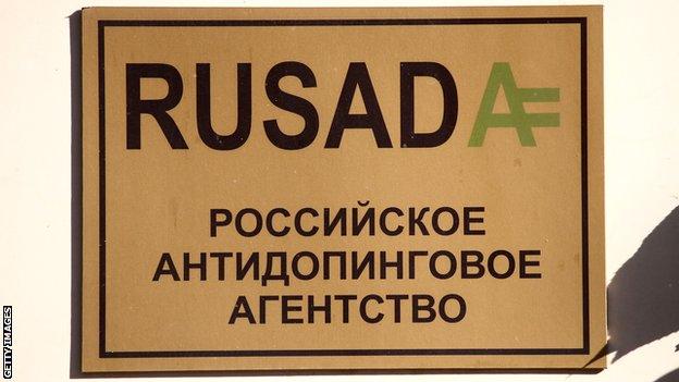 A gold sign with black lettering of the name Rusada, outside the the Russian anti-doping agency in Moscow
