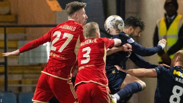 Aberdeen's Jack MacKenzie concedes a penalty against Dundee