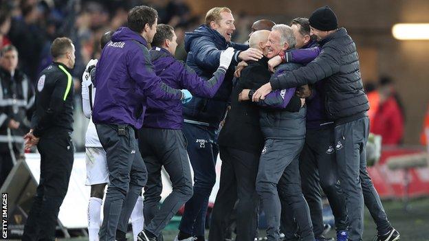 Swansea backroom staff celebrate at the final whistle