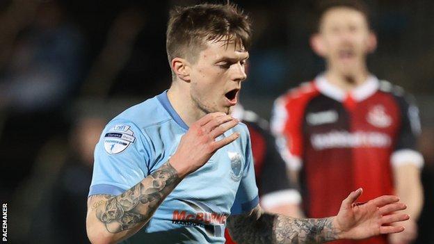 Paul McElroy missed the chance to level for Ballymena when he fired wide from the penalty spot