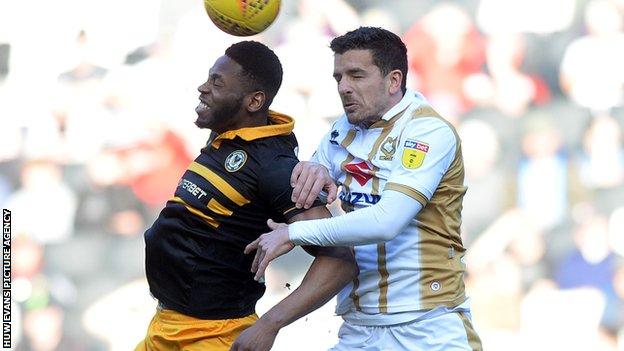 Mathieu Baudry of MK Dons goes for a header with Newport's Jamille Matt