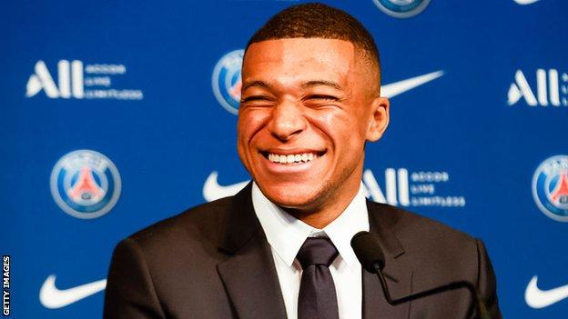 Kylian Mabppe smiling at a press conference