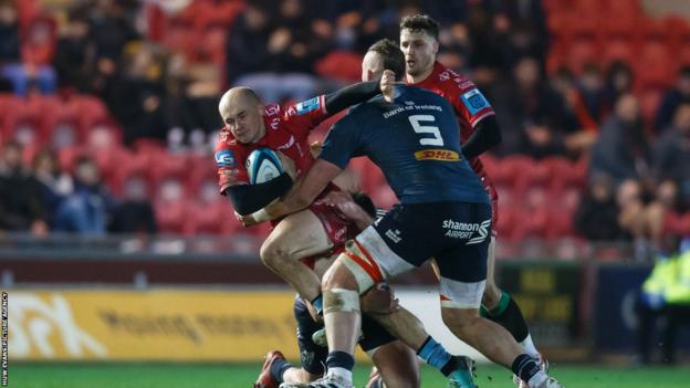 Ioan Nicholas of Scarlets takes on RG Snyman of Munster