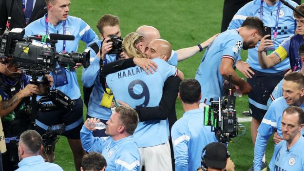 Pep Guardiola hugs striker Erling Haaland after Manchester City complete the Treble