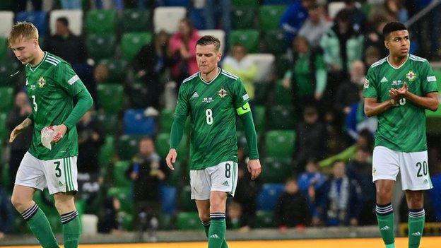Northern Ireland players show their disappointment after the home defeat by Greece