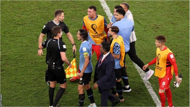 Uruguay players remonstrate with the referee and assistant referee after their win over Ghana