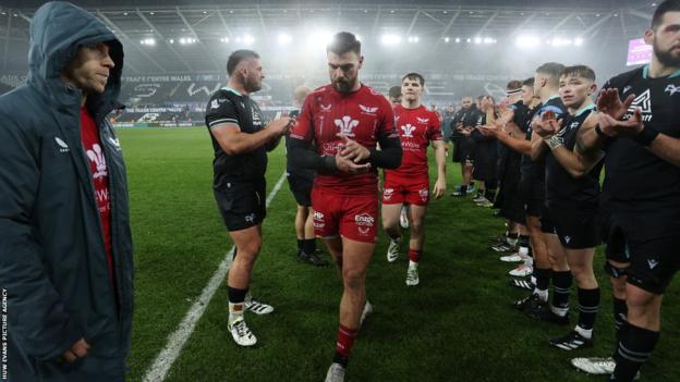Scarlets players Johnny Williams and Gareth Davies trudge off in defeat against Ospreys in Swansea